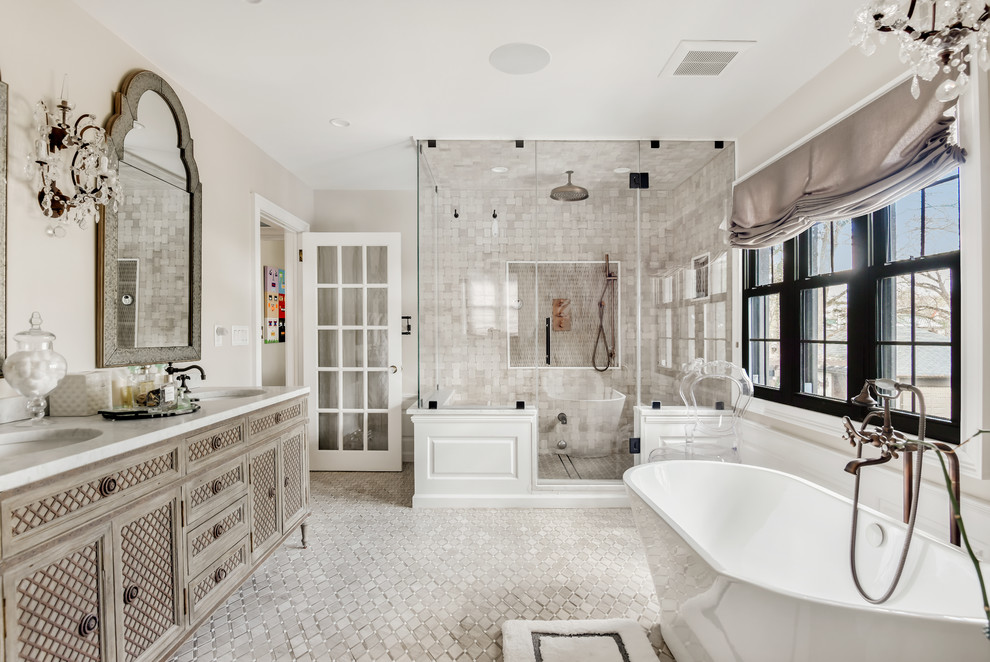 Klassisk inredning av ett grå grått en-suite badrum, med skåp i ljust trä, ett fristående badkar, grå kakel, beige väggar, ett undermonterad handfat, grått golv, dusch med gångjärnsdörr och luckor med infälld panel