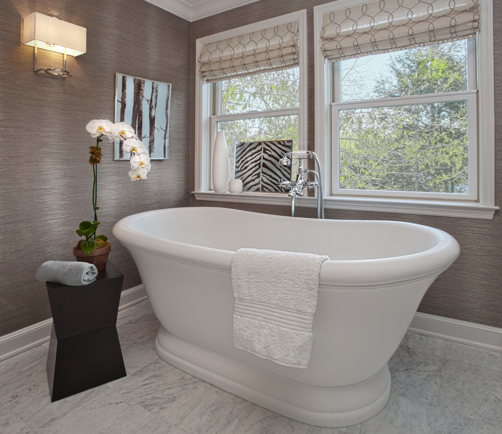 Transitional freestanding bathtub photo in New York with gray walls