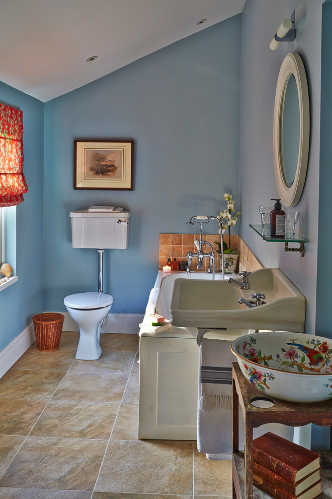Inspiration for a medium sized eclectic family bathroom in Hampshire with raised-panel cabinets, white cabinets, a corner bath, a two-piece toilet, white tiles, ceramic tiles, blue walls, slate flooring, a pedestal sink, tiled worktops and yellow floors.
