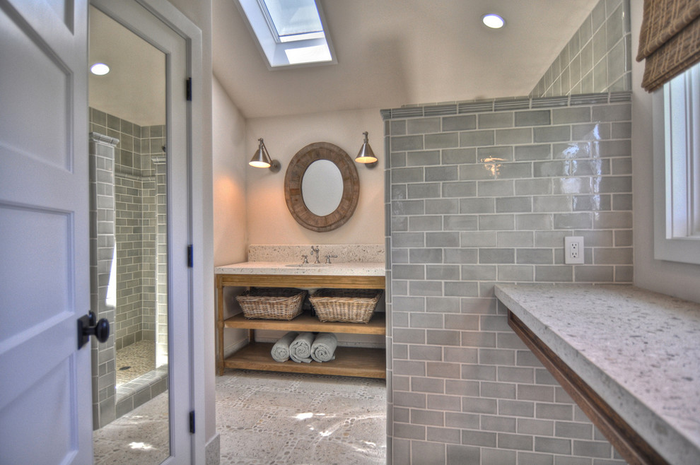Example of a transitional gray tile and subway tile doorless shower design in Orange County with an undermount sink, concrete countertops, open cabinets, distressed cabinets and gray walls