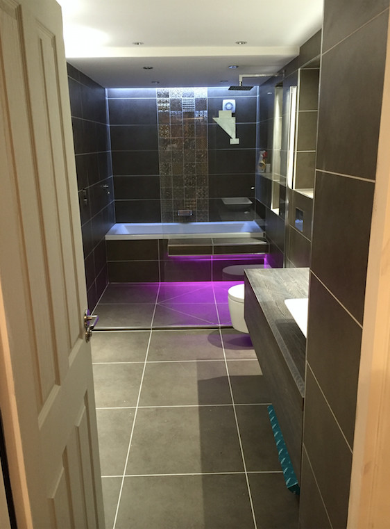 Imagen de cuarto de baño bohemio con sanitario de pared y baldosas y/o azulejos grises