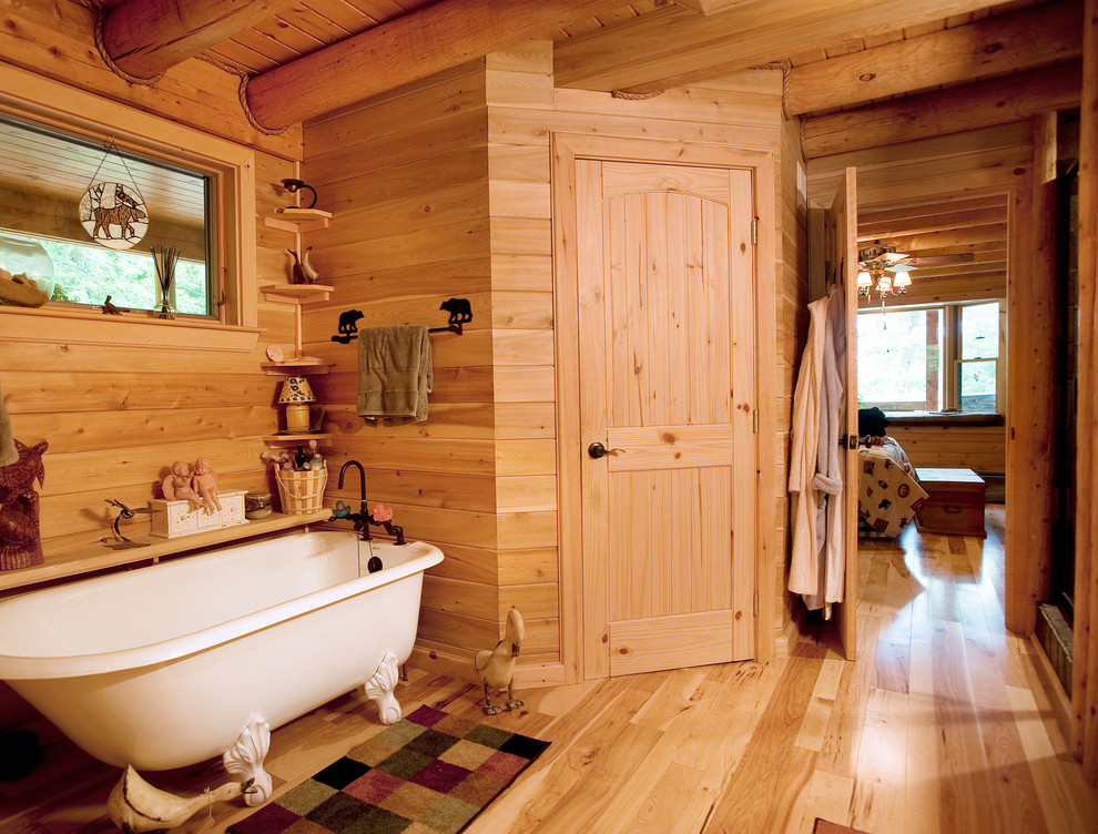 Foto de cuarto de baño principal rústico pequeño con bañera con patas y suelo de madera en tonos medios