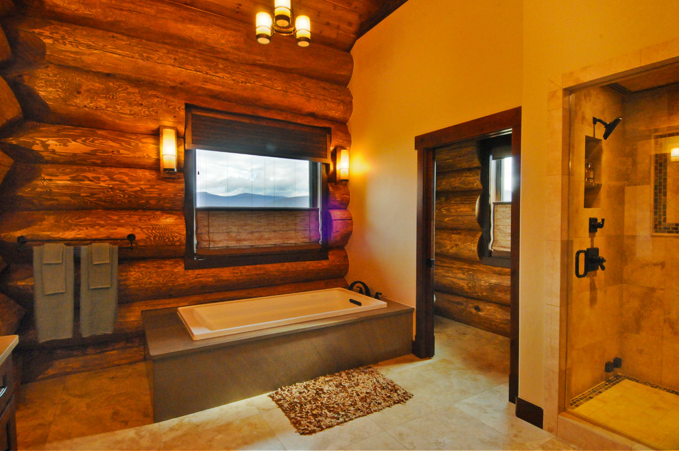 Example of a mid-sized mountain style master travertine tile travertine floor bathroom design in Denver with a hinged shower door
