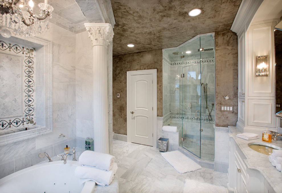 Foto di una grande stanza da bagno padronale classica con lavabo sottopiano, ante a filo, ante bianche, top in marmo, vasca ad alcova, doccia doppia, piastrelle grigie, piastrelle in pietra, pareti grigie e pavimento in marmo