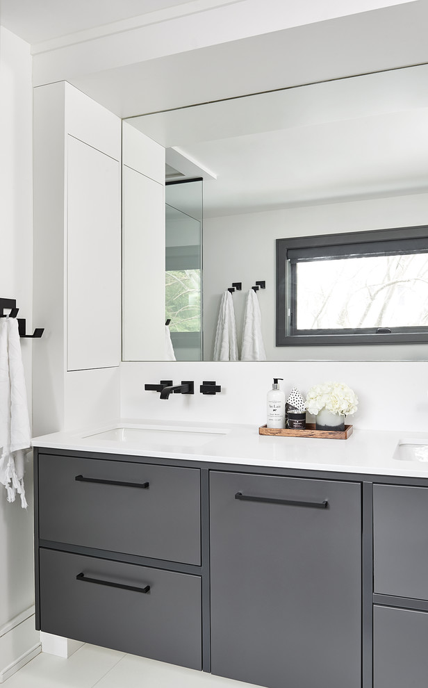 Inredning av ett modernt mellanstort vit vitt en-suite badrum, med släta luckor, grå skåp, ett fristående badkar, porslinskakel, vita väggar, klinkergolv i porslin, ett undermonterad handfat, bänkskiva i kvarts, vitt golv och dusch med gångjärnsdörr