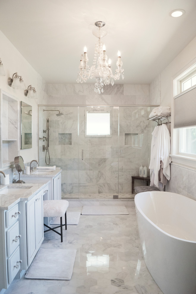 Exempel på ett maritimt grå grått en-suite badrum, med luckor med infälld panel, vita skåp, ett fristående badkar, en dusch i en alkov, grå kakel, vit kakel, marmorkakel, grå väggar, marmorgolv, ett undermonterad handfat, marmorbänkskiva, grått golv och dusch med gångjärnsdörr