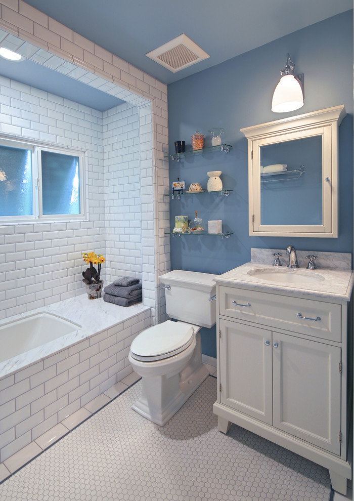 Idéer för att renovera ett litet vintage badrum med dusch, med ett undermonterad handfat, vita skåp, marmorbänkskiva, ett undermonterat badkar, en dusch/badkar-kombination, en toalettstol med separat cisternkåpa, vit kakel, keramikplattor, blå väggar, klinkergolv i keramik och skåp i shakerstil