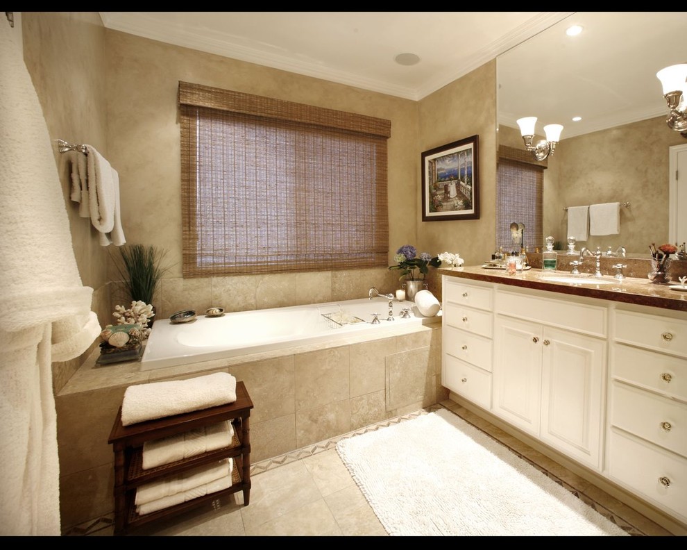 Drop-in bathtub - large transitional master beige tile and porcelain tile porcelain tile drop-in bathtub idea in Los Angeles with an undermount sink, raised-panel cabinets, white cabinets, granite countertops and beige walls