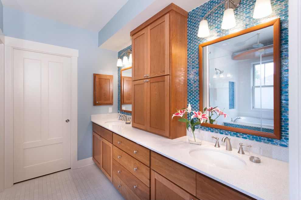 Esempio di una stanza da bagno padronale american style di medie dimensioni con lavabo sottopiano, ante in stile shaker, ante in legno scuro, top in quarzo composito, piastrelle blu, piastrelle di vetro, pareti blu e pavimento in gres porcellanato