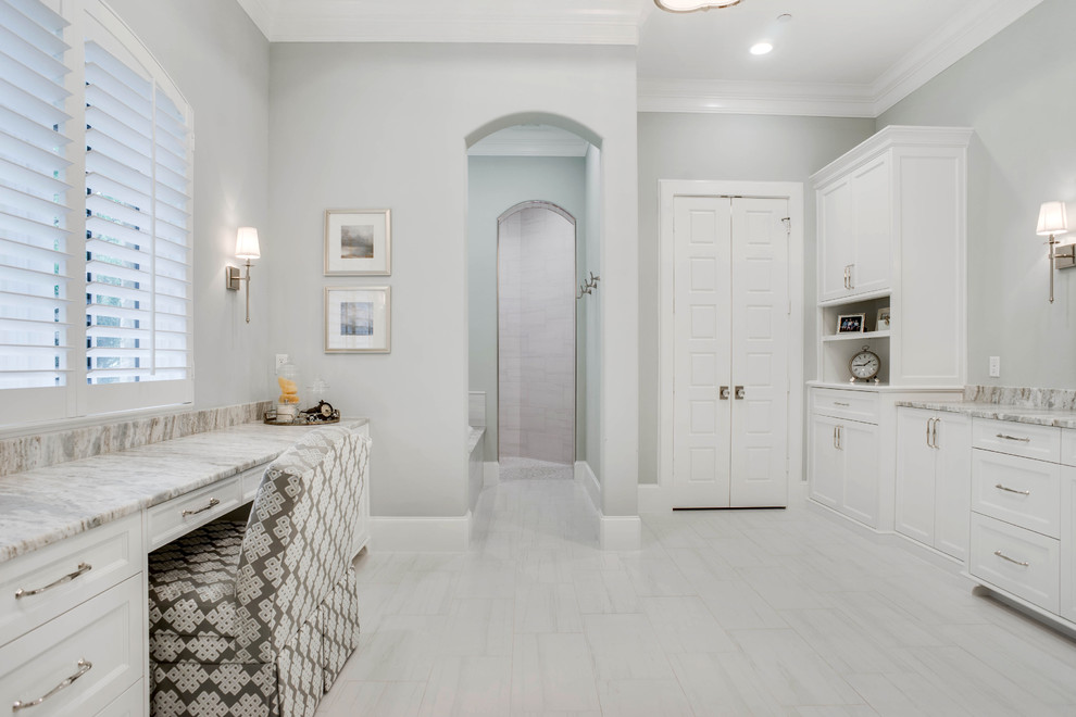 Photo of a large traditional ensuite bathroom in Dallas with recessed-panel cabinets, white cabinets, an alcove bath, a walk-in shower, a one-piece toilet, blue tiles, blue walls, porcelain flooring, a submerged sink, marble worktops, white floors and an open shower.