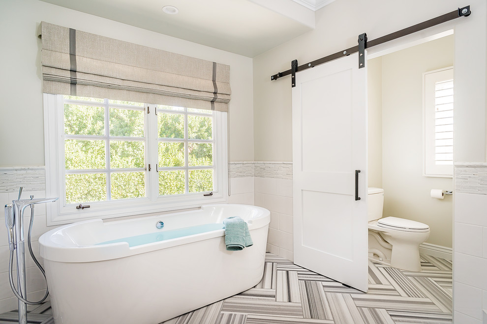 Freestanding bathtub - large transitional master white tile marble floor freestanding bathtub idea in Los Angeles with a two-piece toilet and beige walls