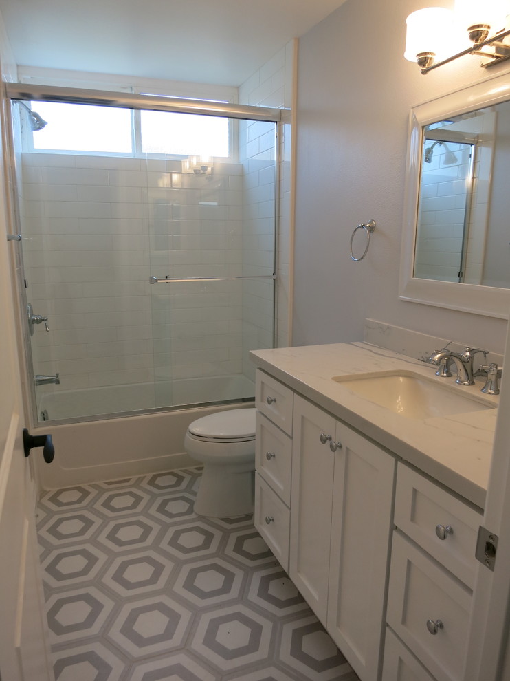 Inredning av ett klassiskt mellanstort badrum med dusch, med skåp i shakerstil, vita skåp, ett badkar i en alkov, en dusch/badkar-kombination, vit kakel, tunnelbanekakel, grå väggar, klinkergolv i porslin, ett undermonterad handfat, bänkskiva i kvarts, grått golv och dusch med skjutdörr