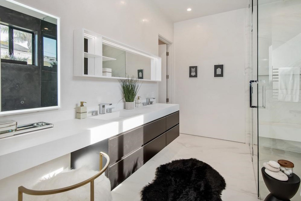 Стильный дизайн: большая главная ванная комната в современном стиле с плоскими фасадами, коричневыми фасадами, отдельно стоящей ванной, душевой комнатой, унитазом-моноблоком, белой плиткой, белыми стенами, полом из керамогранита, монолитной раковиной, белым полом, душем с распашными дверями, белой столешницей и столешницей из искусственного кварца - последний тренд