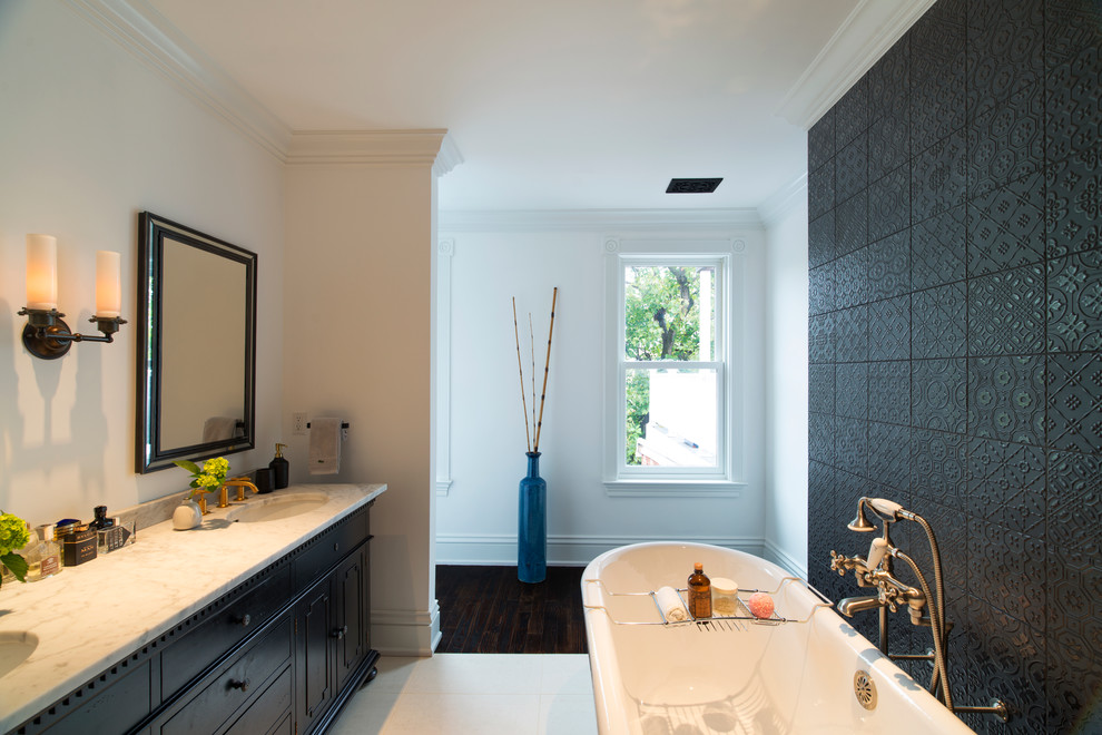 Inspiration for a large traditional ensuite bathroom in Baltimore with freestanding cabinets, black cabinets, a claw-foot bath, black tiles, cement tiles, white walls, porcelain flooring, a submerged sink, engineered stone worktops and white floors.