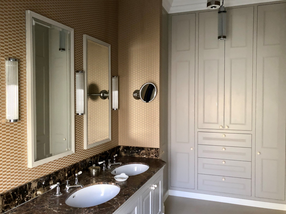 Cette photo montre une grande salle de bain principale éclectique avec un placard avec porte à panneau surélevé, des portes de placard beiges, une baignoire en alcôve, un combiné douche/baignoire, WC à poser, un carrelage blanc, des carreaux de porcelaine, un mur marron, un sol en linoléum, un lavabo intégré, un plan de toilette en marbre, un sol beige, une cabine de douche à porte battante, un plan de toilette marron, meuble double vasque, meuble-lavabo encastré et du papier peint.