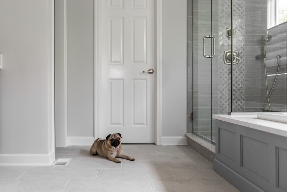 Inspiration for a large classic ensuite bathroom in Chicago with recessed-panel cabinets, grey cabinets, a corner bath, a corner shower, grey tiles, ceramic tiles, grey walls, ceramic flooring, a submerged sink, quartz worktops, grey floors, a hinged door and white worktops.