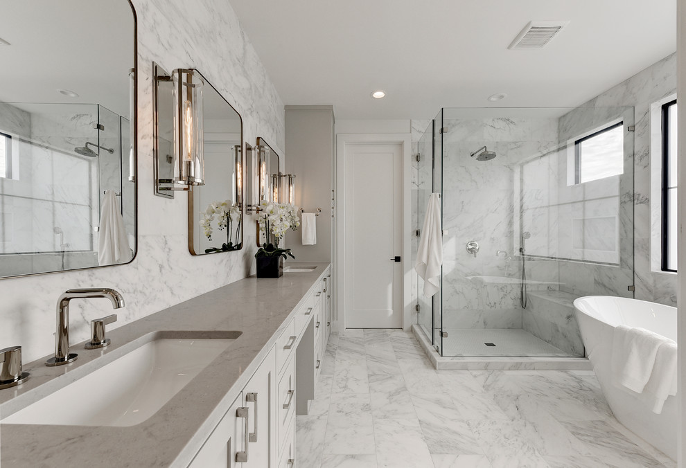 Photo of a classic bathroom in Austin with shaker cabinets, white cabinets, a freestanding bath, a submerged sink, white floors and grey worktops.