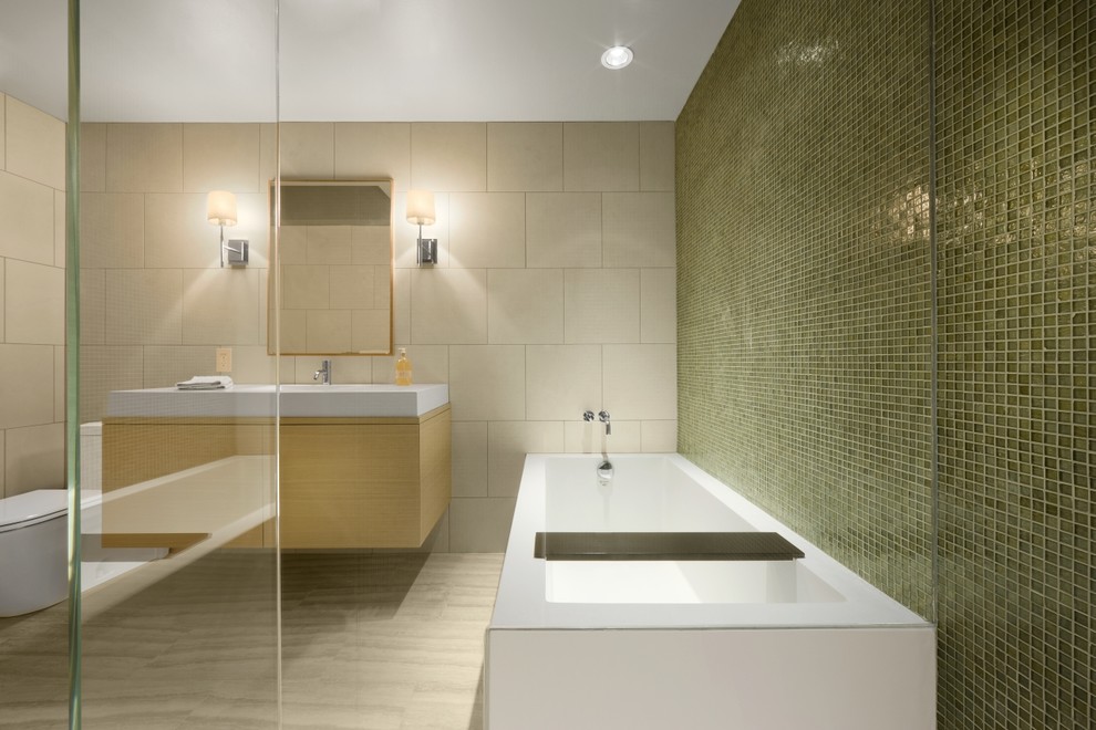 Imagen de cuarto de baño minimalista con bañera exenta, baldosas y/o azulejos en mosaico y lavabo integrado