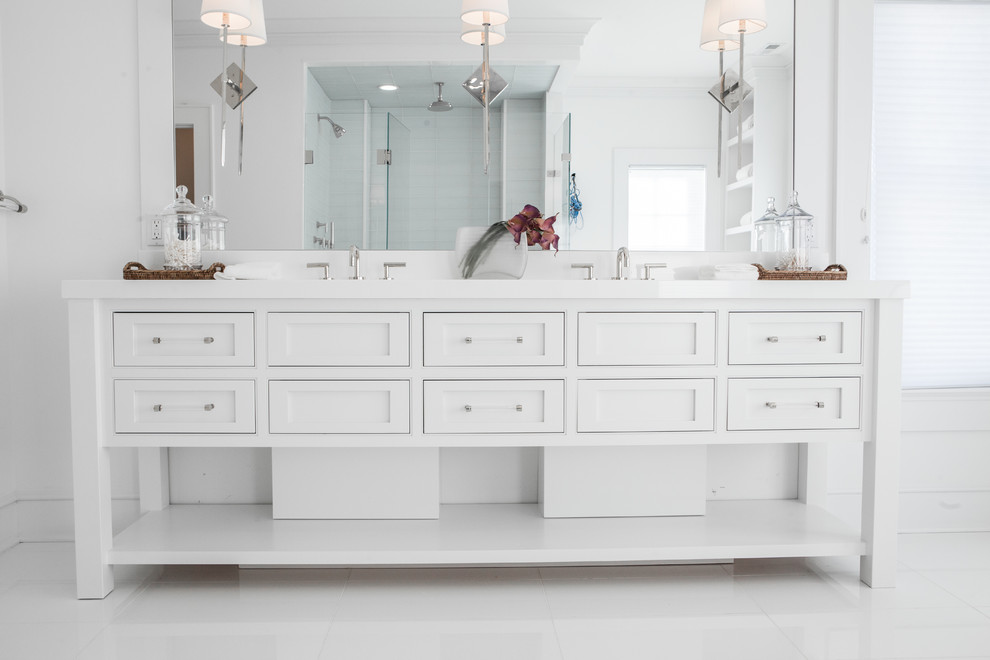 Imagen de cuarto de baño principal tradicional renovado grande con armarios con rebordes decorativos, puertas de armario blancas, bañera exenta, paredes blancas y suelo blanco