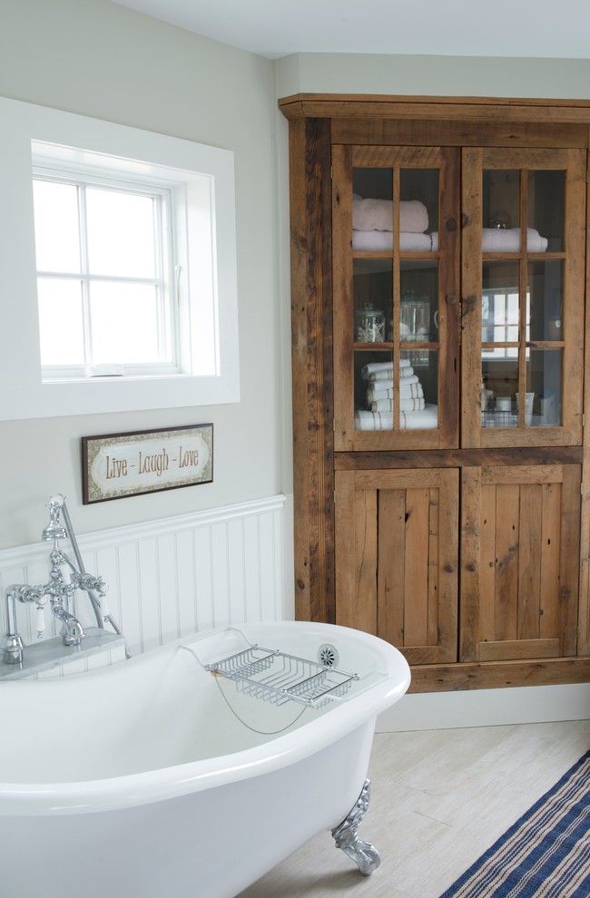 Inspiration för mellanstora maritima en-suite badrum, med ett badkar med tassar, skåp i slitet trä, beige väggar, klinkergolv i porslin, marmorbänkskiva, beiget golv och skåp i shakerstil