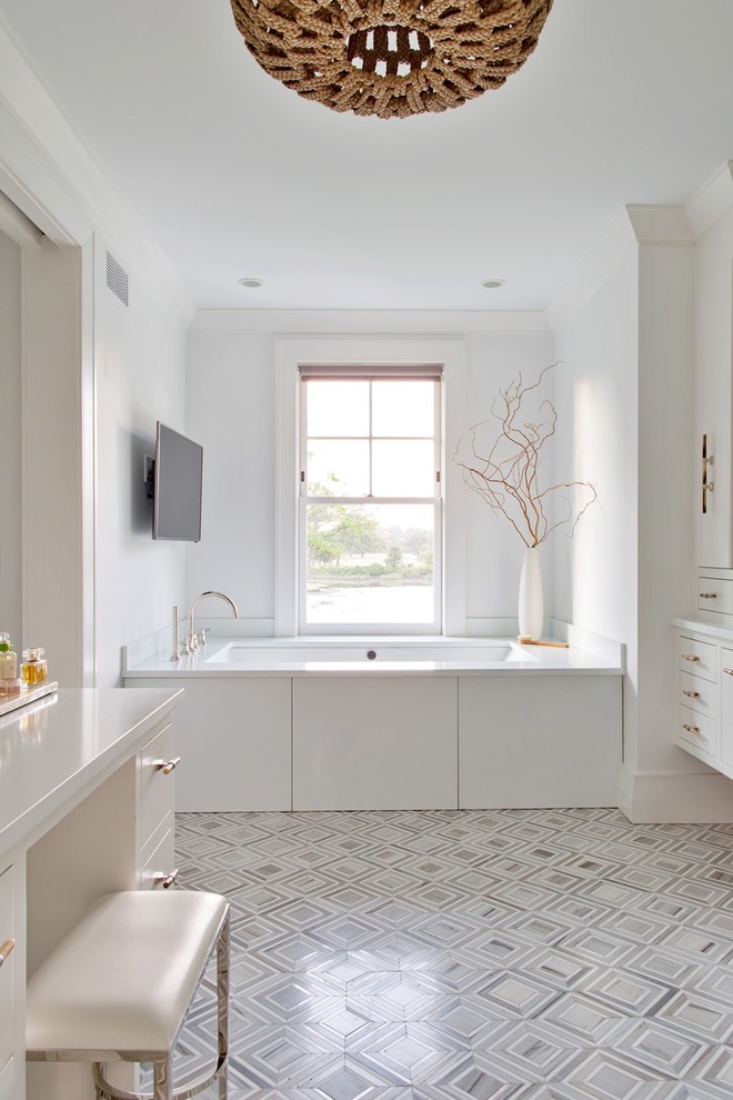 На фото: большая главная ванная комната в стиле неоклассика (современная классика) с белыми фасадами, белой столешницей, фасадами в стиле шейкер, ванной в нише и серым полом