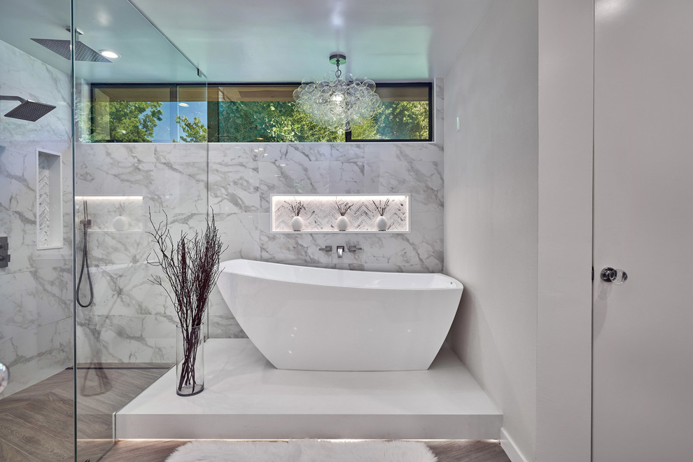 Idéer för funkis en-suite badrum, med ett fristående badkar, en kantlös dusch, vit kakel, vita väggar, brunt golv och dusch med gångjärnsdörr