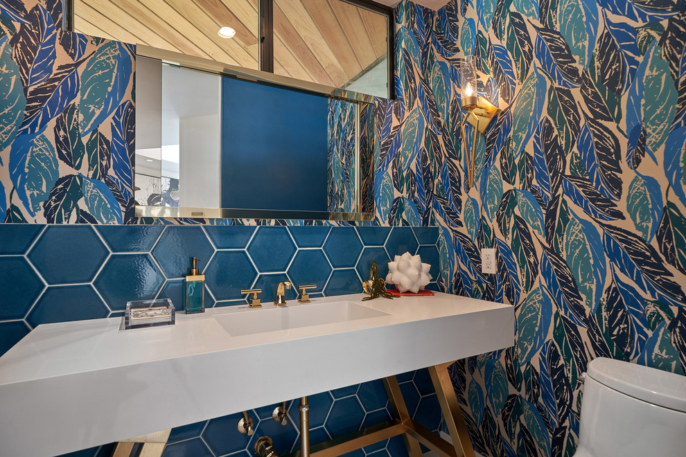На фото: ванная комната в современном стиле с белыми фасадами, синей плиткой, синими стенами, консольной раковиной и белой столешницей