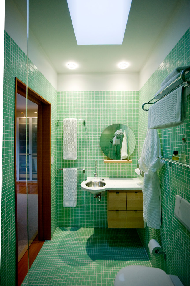 На фото: ванная комната в современном стиле с врезной раковиной, плоскими фасадами, зеленой плиткой и плиткой мозаикой