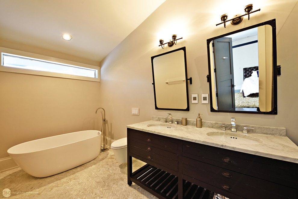 Idée de décoration pour une grande salle de bain design en bois foncé avec une baignoire indépendante, un mur gris, un sol en marbre, un plan de toilette en marbre, un placard en trompe-l'oeil, une douche ouverte, un lavabo encastré et WC suspendus.
