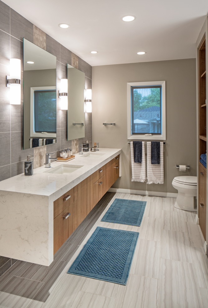 Inspiration for a mid-sized contemporary master white tile and porcelain tile porcelain tile walk-in shower remodel in Omaha with flat-panel cabinets, medium tone wood cabinets, a one-piece toilet, gray walls, an undermount sink and quartz countertops