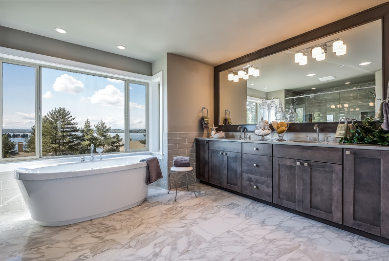 Photo of a large contemporary ensuite bathroom in Seattle with recessed-panel cabinets, dark wood cabinets, a freestanding bath, a double shower, a two-piece toilet, grey tiles, ceramic tiles, grey walls, porcelain flooring, a submerged sink and engineered stone worktops.