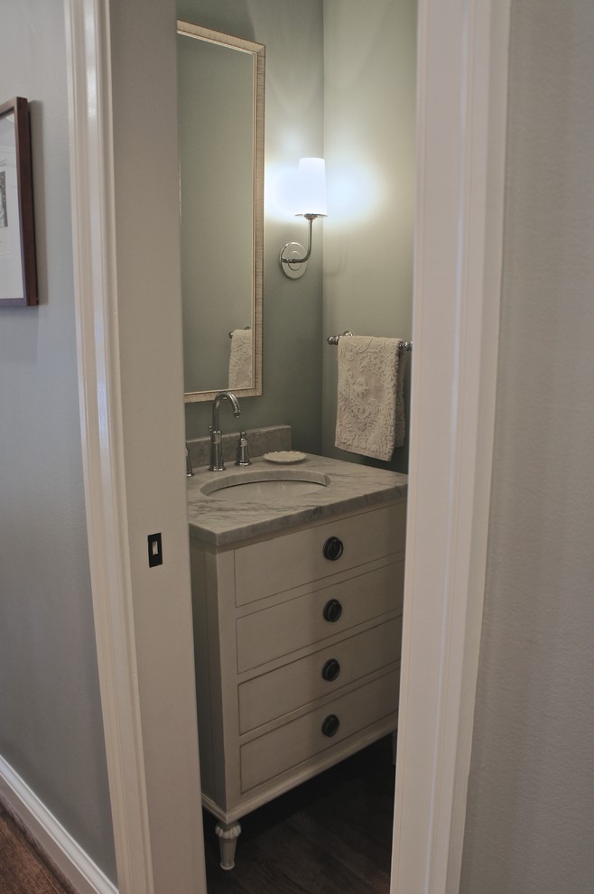 Cette image montre une petite salle de bain traditionnelle avec un lavabo encastré, un placard en trompe-l'oeil, des portes de placard blanches, un plan de toilette en marbre, une baignoire en alcôve, WC à poser, un mur bleu et parquet clair.