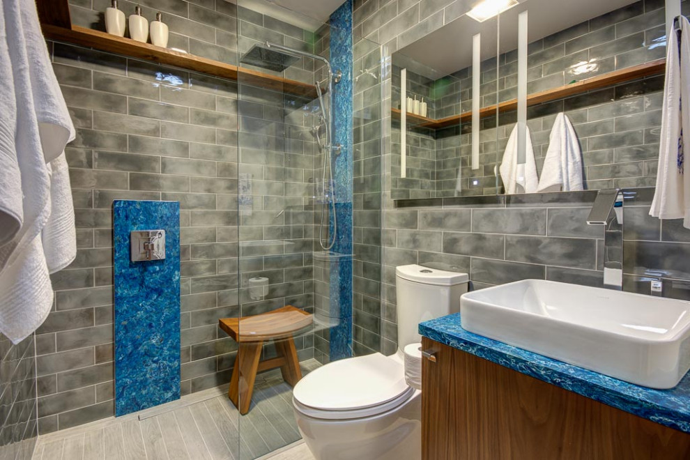 シアトルにある小さなエクレクティックスタイルのおしゃれなバスルーム (浴槽なし) (中間色木目調キャビネット、バリアフリー、グレーのタイル、グレーの壁、グレーの床、オープンシャワー、青い洗面カウンター) の写真