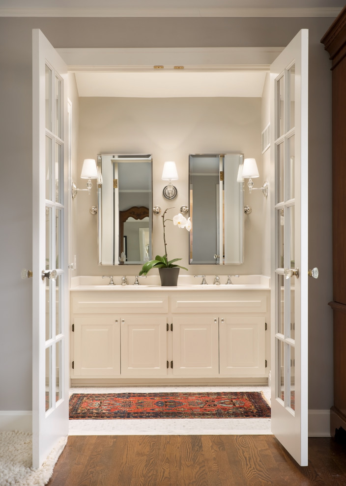 Design ideas for a traditional bathroom in Kansas City with raised-panel cabinets, white cabinets and grey walls.