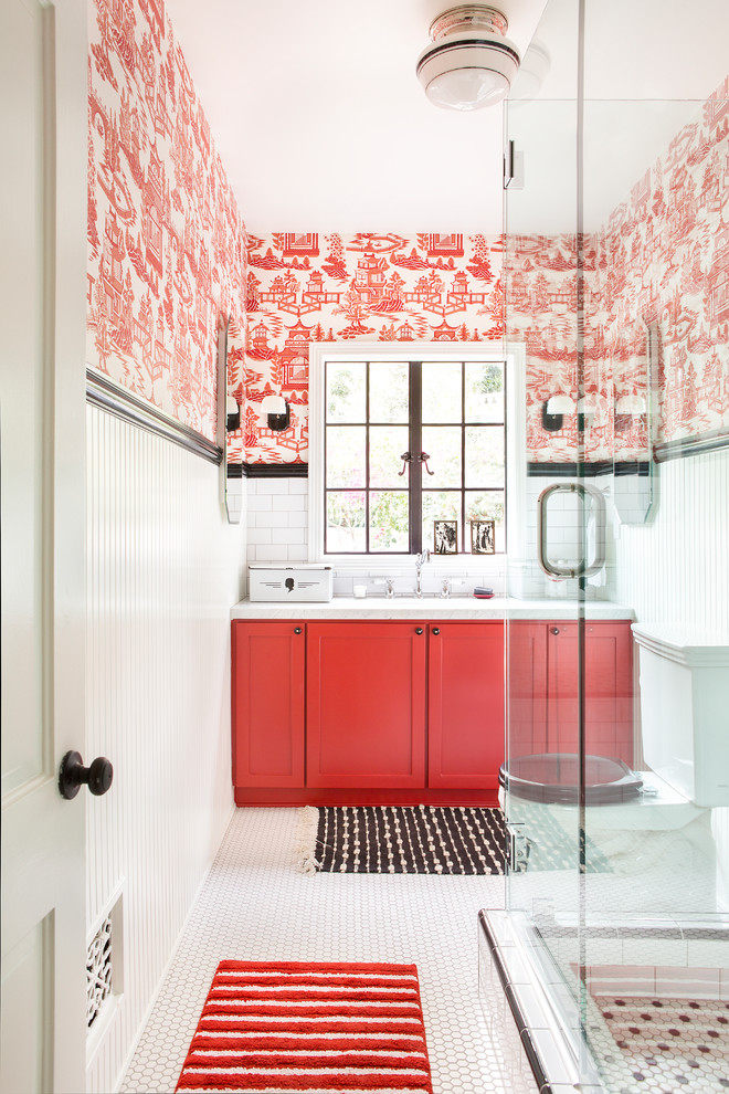 Inspiration for a cottage 3/4 white tile and subway tile mosaic tile floor, white floor, single-sink and wallpaper corner shower remodel in Los Angeles with shaker cabinets, red cabinets, a two-piece toilet, red walls, a hinged shower door, an undermount sink, marble countertops, white countertops and a built-in vanity