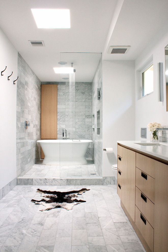 Inspiration pour une salle de bain principale design en bois clair de taille moyenne avec un lavabo encastré, un placard à porte plane, un plan de toilette en quartz, une baignoire indépendante, une douche ouverte, un carrelage gris, un carrelage de pierre, un mur blanc et un sol en marbre.