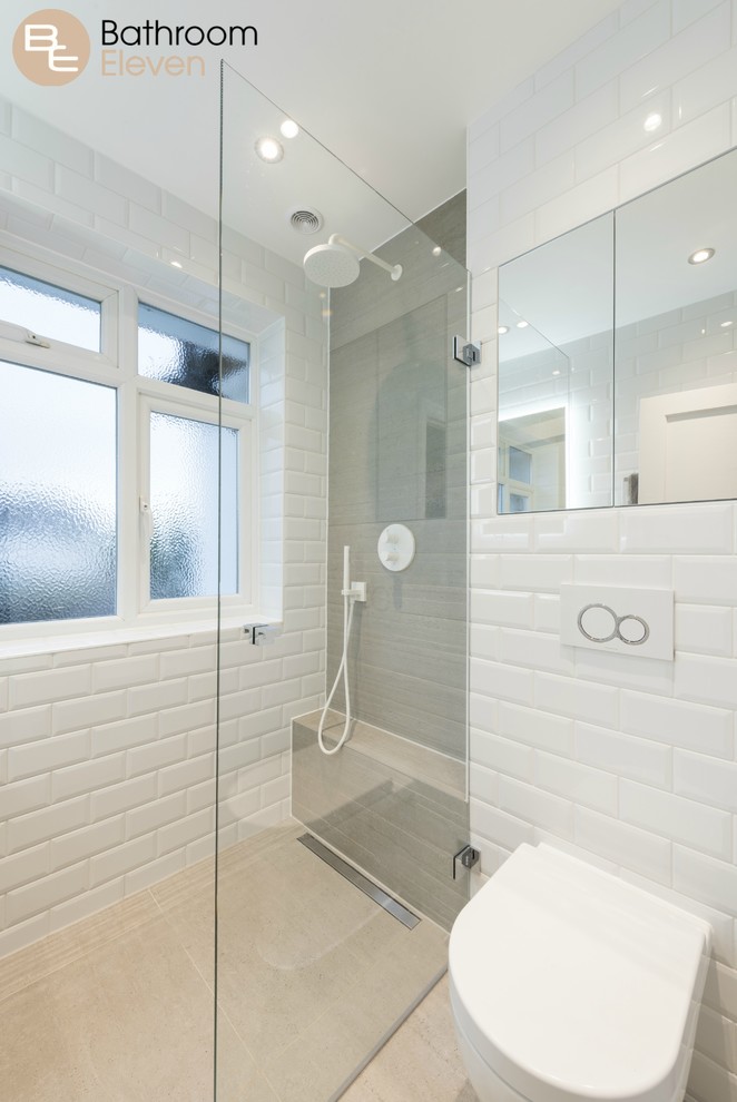 This is an example of a small contemporary wet room bathroom with white walls, a one-piece toilet, ceramic flooring, a wall-mounted sink, white tiles, ceramic tiles, solid surface worktops, beige floors, an open shower and white worktops.