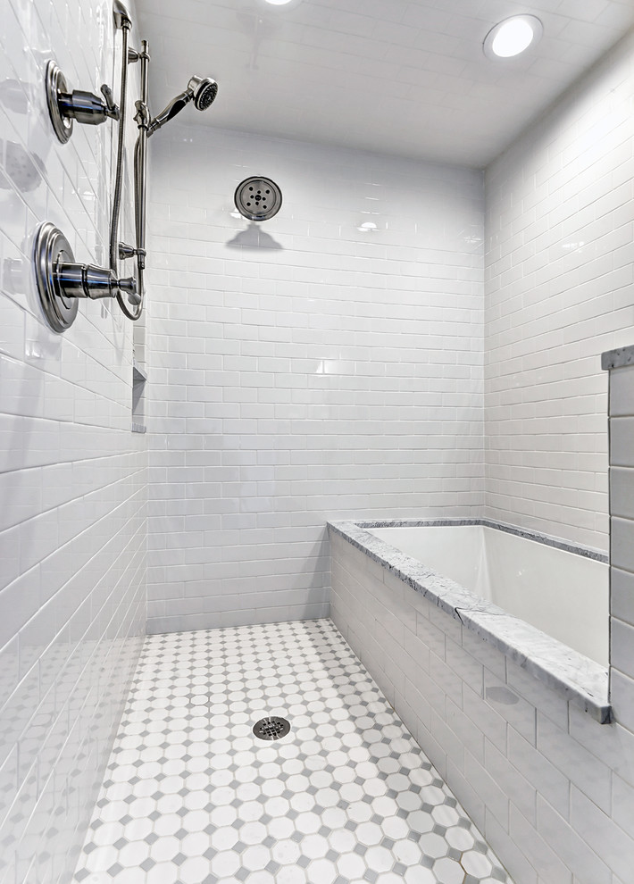 Klassisk inredning av ett mellanstort badrum, med ett undermonterad handfat, släta luckor, vita skåp, marmorbänkskiva, ett undermonterat badkar, en toalettstol med separat cisternkåpa, vit kakel, keramikplattor, vita väggar, klinkergolv i keramik, en dubbeldusch och med dusch som är öppen