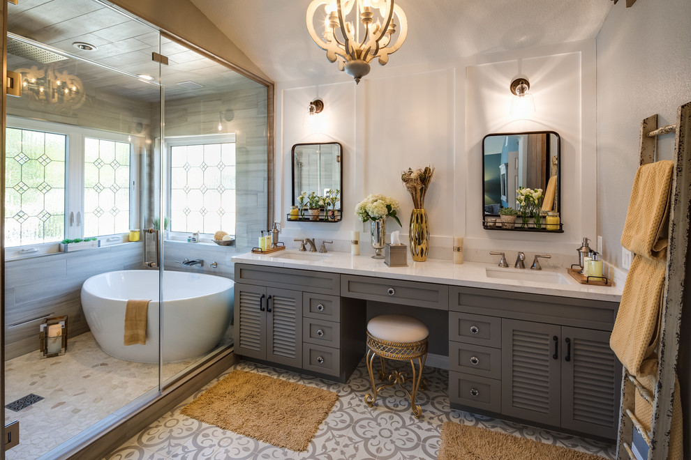 Example of a large transitional master gray tile and porcelain tile porcelain tile and multicolored floor bathroom design in San Diego with louvered cabinets, dark wood cabinets, beige walls, an undermount sink, solid surface countertops and a hinged shower door