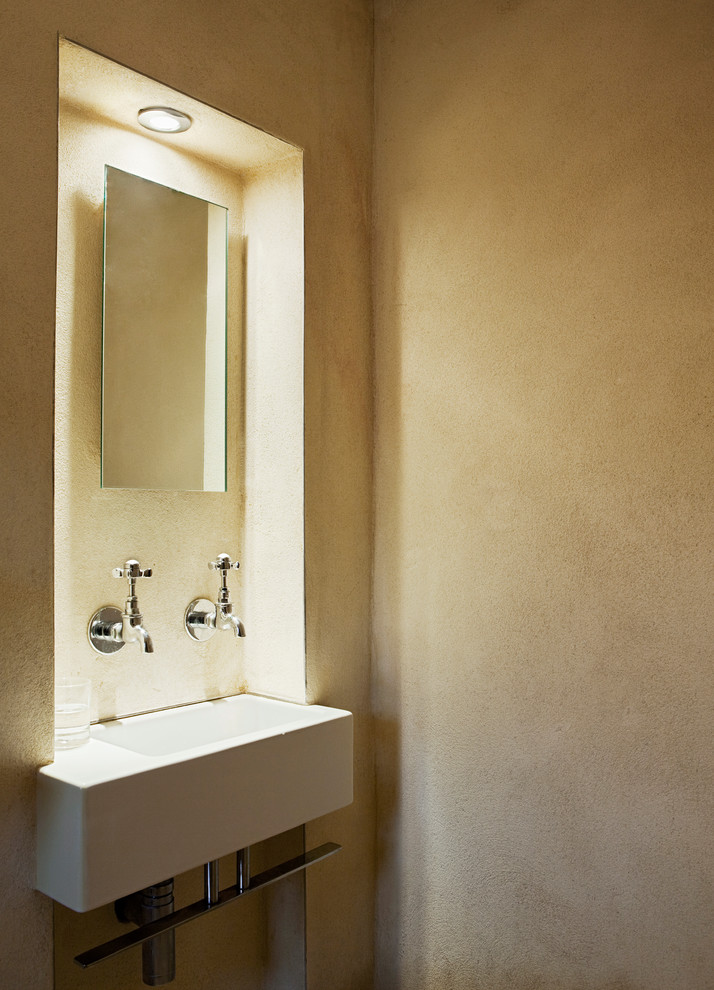 Immagine di una piccola stanza da bagno contemporanea con lavabo integrato, doccia aperta, WC a due pezzi, piastrelle in pietra, pareti gialle e pavimento in pietra calcarea