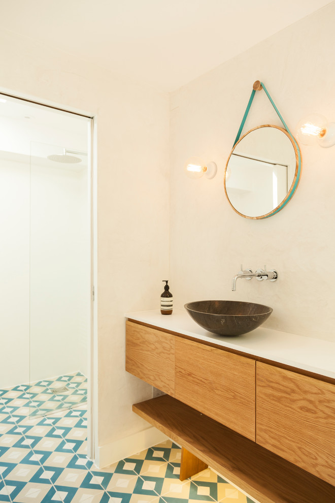 This is an example of a small scandinavian ensuite bathroom in London with flat-panel cabinets, medium wood cabinets, quartz worktops, a built-in shower, a vessel sink and white walls.