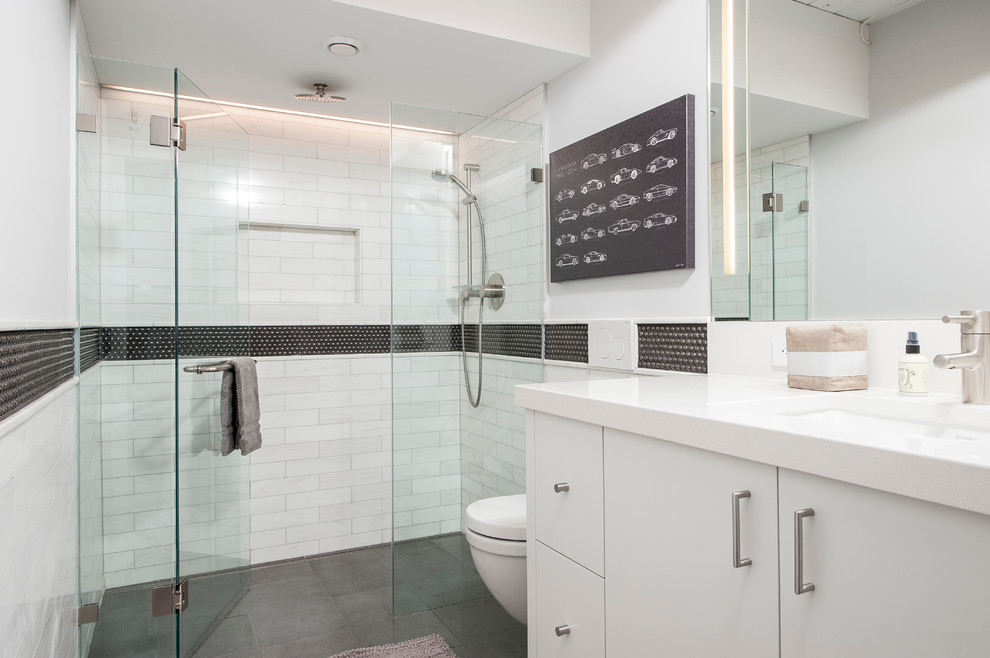 Exemple d'une salle de bain industrielle de taille moyenne pour enfant avec un placard à porte plane, des portes de placard blanches, une douche double, WC suspendus, un carrelage noir et blanc, un mur blanc, parquet clair et un lavabo encastré.