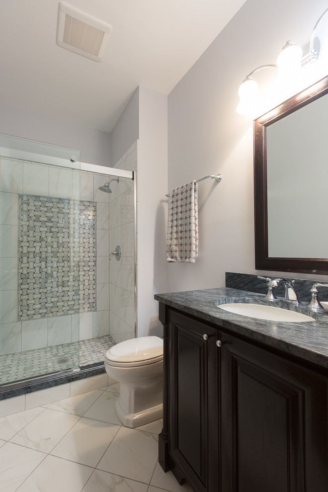 Inspiration for a mid-sized timeless 3/4 white tile and porcelain tile porcelain tile alcove shower remodel in Chicago with raised-panel cabinets, dark wood cabinets, soapstone countertops, an undermount sink, a one-piece toilet and gray walls