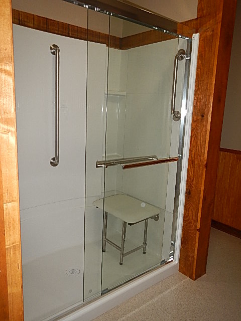 Immagine di una stanza da bagno chic di medie dimensioni con ante di vetro, doccia alcova, pareti beige, pavimento beige e porta doccia scorrevole
