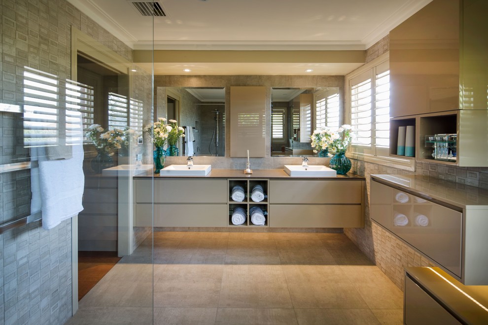 Example of a mid-sized trendy master beige tile and porcelain tile porcelain tile walk-in shower design in Melbourne with raised-panel cabinets, beige cabinets, a one-piece toilet, beige walls, a drop-in sink and quartz countertops