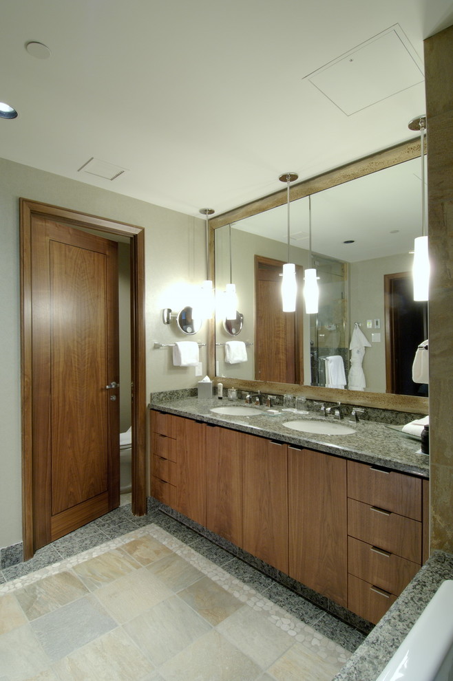 Réalisation d'une salle de bain design avec un plan de toilette en granite.