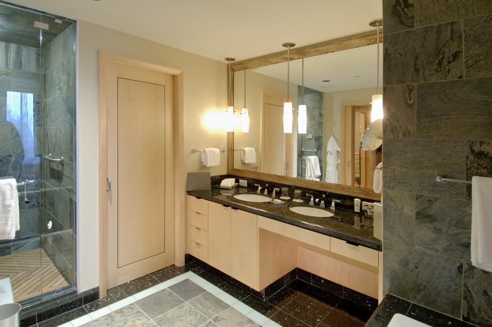 Inspiration för moderna badrum, med ett undermonterad handfat, släta luckor, skåp i ljust trä, en dusch i en alkov och grå kakel