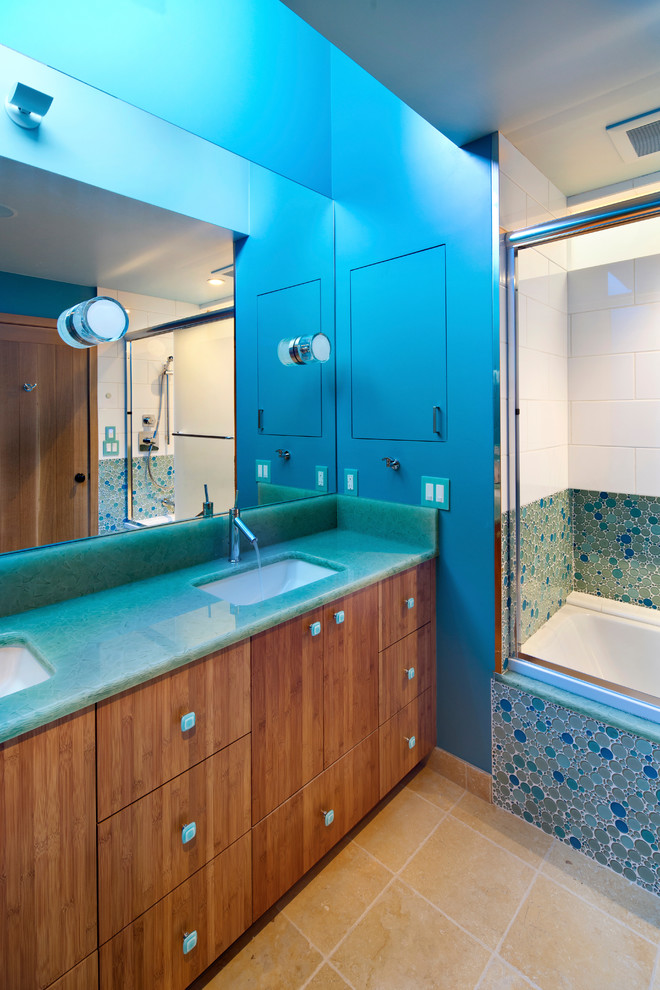 Ispirazione per una stanza da bagno minimal con lavabo sottopiano, ante lisce, ante in legno scuro, vasca ad alcova, vasca/doccia, piastrelle blu e pareti blu