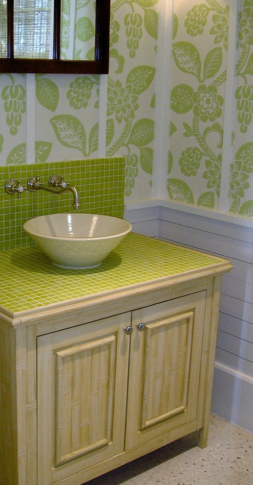 Cette image montre une salle de bain marine en bois clair de taille moyenne avec une vasque, un plan de toilette en carrelage, un carrelage vert, mosaïque et un mur vert.