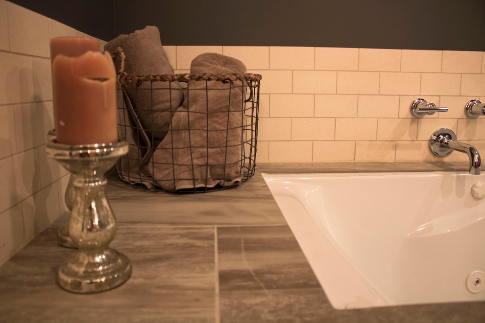 Idee per una grande stanza da bagno padronale industriale con vasca sottopiano, piastrelle grigie, piastrelle in pietra e pareti grigie